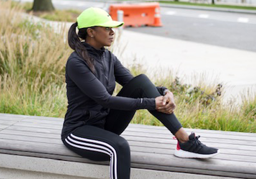A woman poses on a bench and looks off into the distance A woman poses on a bench and looks off into the distance